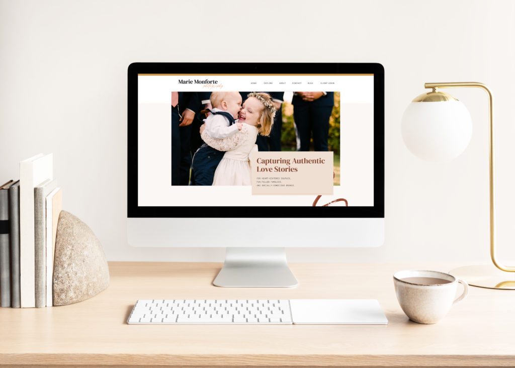 Image depicts Marie Monforte Photography's new website on a Mac Desktop computer, sitting atop a clean wooden desk in a minimalistic office setting.