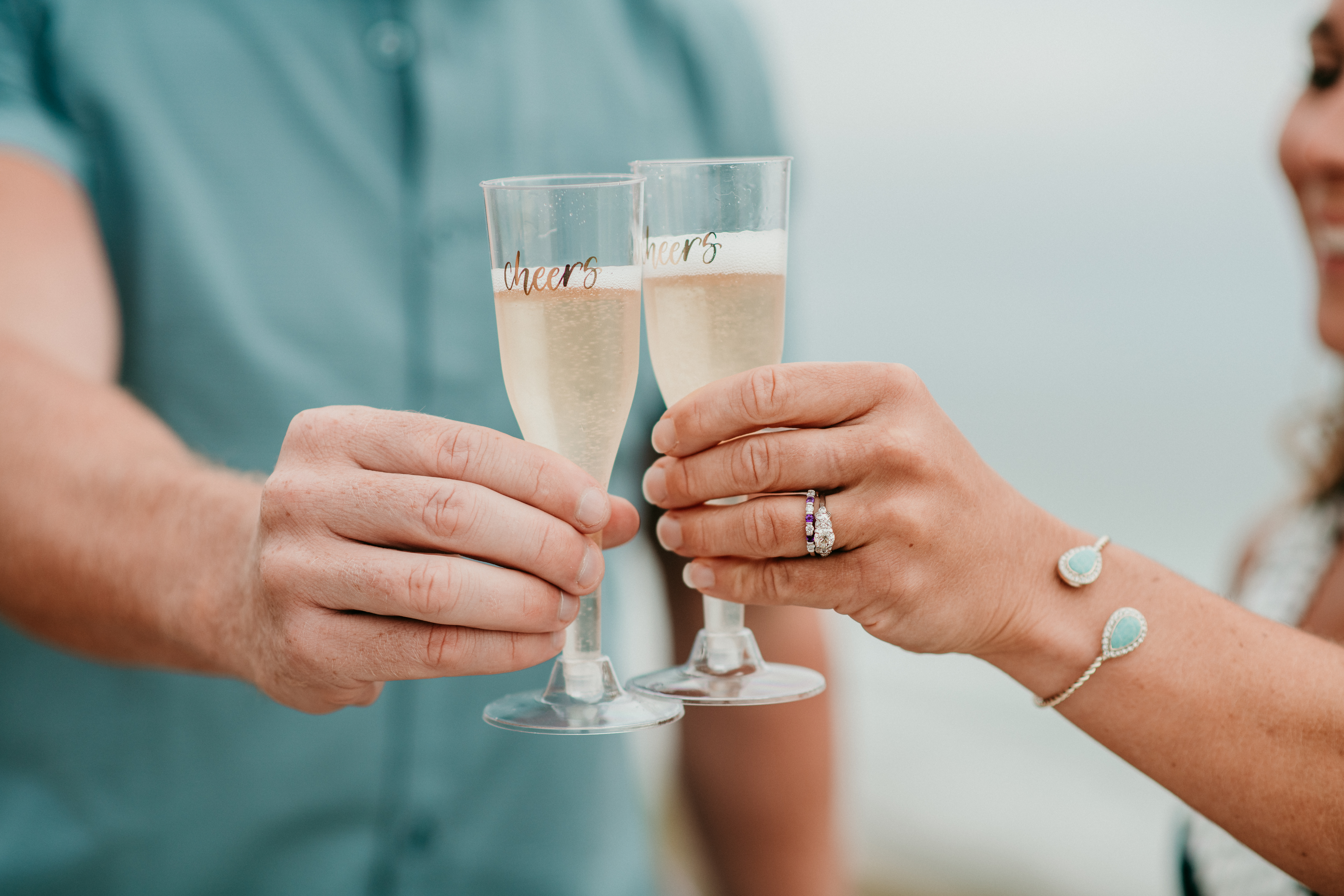 Immediately following his San Diego Proposal, the couple share a toast with Champagne in beach-friendly plastic "Cheers" Flutes