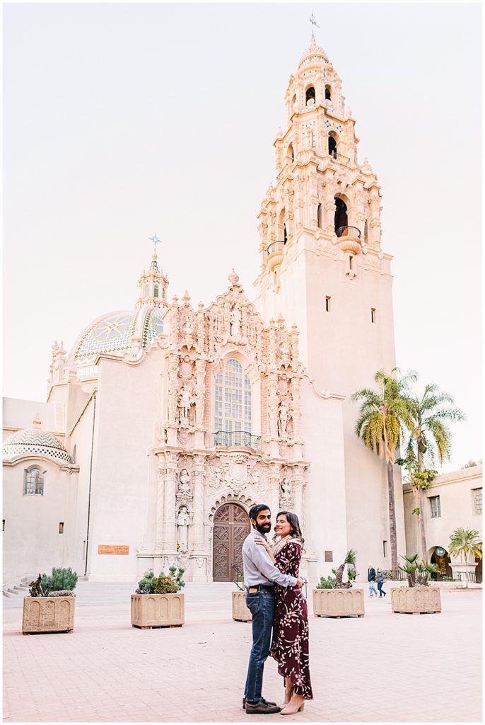 Couple dances in front of Museum of Us - one of Balboa Park's Best engagement photo spots. 