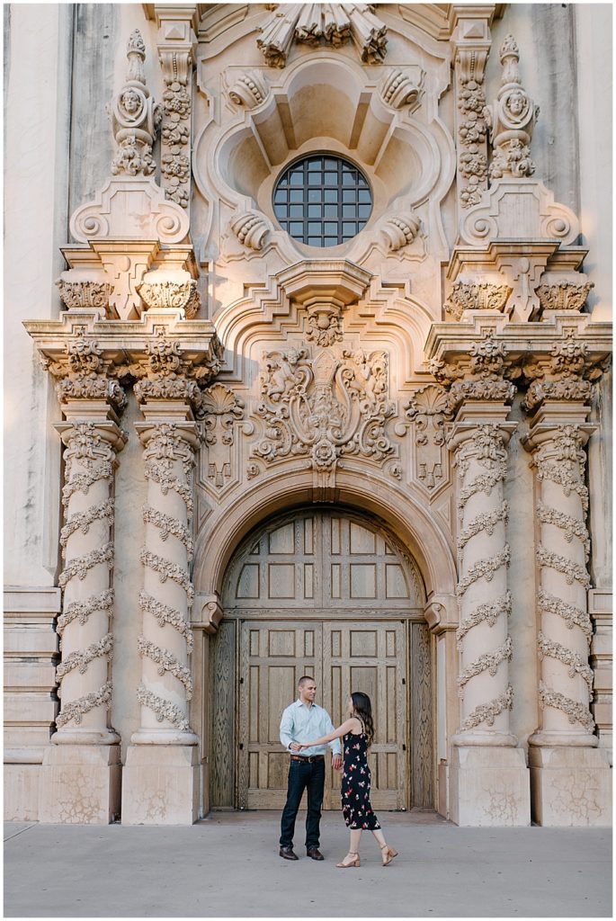 Couple dances in front of Casa del Prado Theatre doors. Renowned for their Baroque and Spanish Colonial styling, this is a popular spot in Balboa Park for engagement session. 