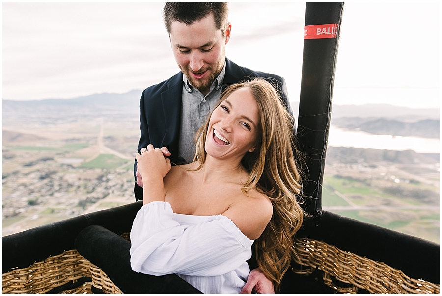 Having just gotten engaged after his romantic Hot Air Balloon Proposal, Jeff and Sara are ecstatic to be officially engaged. In this capture by Temecula Wedding Photographer Marie Monforte Jeff looks at his new fiancee while Sara laughs toward the camera. 